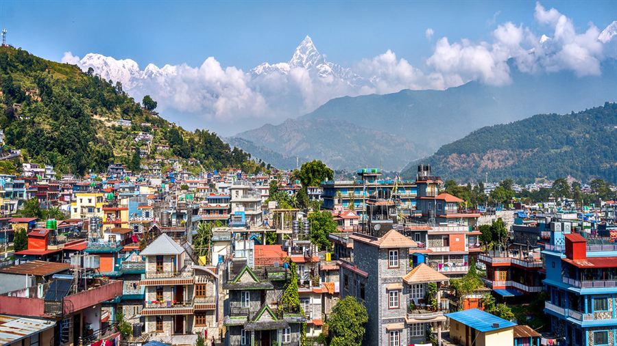 Maisons colorées de Pokhara avec les sommets enneigés de l’Annapurna et du Machhapuchhare en arrière-plan